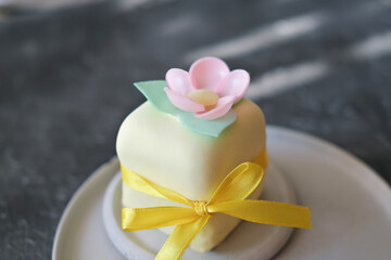 top view of mini cake decorated with edible flowera ns leaves made of rice paper. sweet treat for autumn halloween selebration, ribbon decor. icing cover.