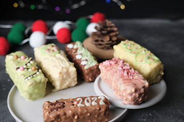 holiday snack, keto protein bars with new year decor on rustic black table. healthy sugar free bars for winter treat.