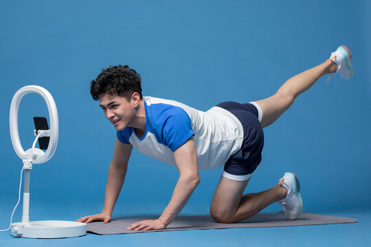 Cheerful young Chinese athlete doing live webcast