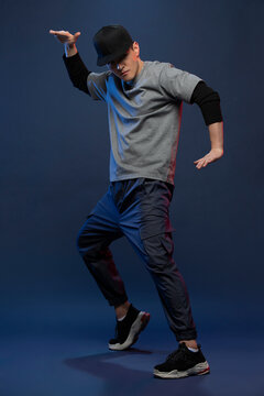 Studio shot of fashionable young Chinese man dancing