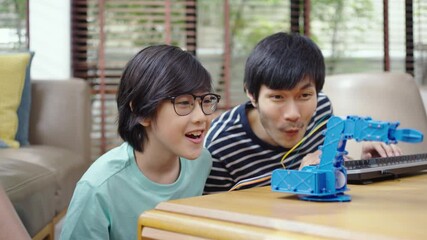 Asian kids program robotic cranes with laptops to learn about technology, math, engineering. programming and coding at home
