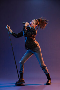 Studio shot of fashionable young woman singing