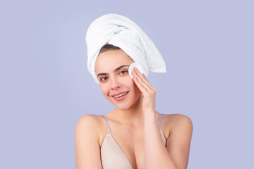 Portrait of young beautiful woman after bath. Beauty face of a cheerful attractive girl with towel on head, isolated. Moisturized healthy skin, morning spa, beauty routine, facial skincare treatment.