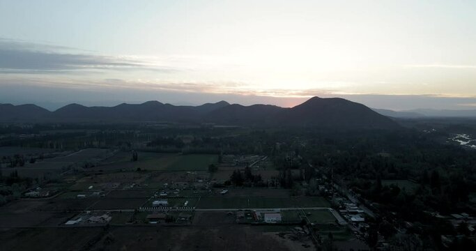 Aerial view of a sunset in Pirque with the mountains in the background as the sun goes down.