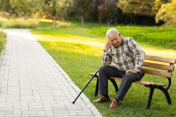 Lonely senior man sitting on park bench