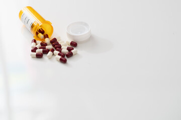 medicine pill tablets spill from medical bottle container on floor in abuse or health vitamins supplement concept