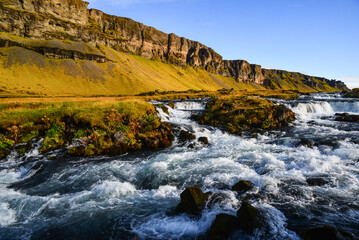 Picturesque Fossálar waterfall right by the Ring Road, surrounded by the cliffs of southern Iceland
