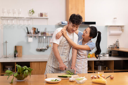 Happy young couple cooking in kitchen
