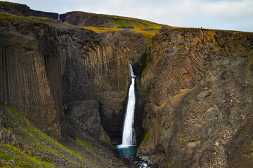 Litlanesfoss waterfall surrounded by basalt columns on the way to taller Hengifoss waterfall, East...