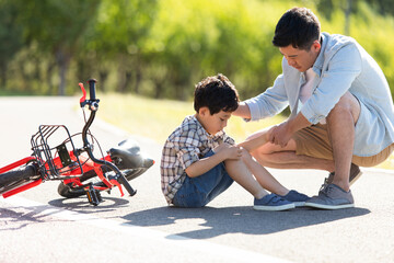Little boy falling off his bike