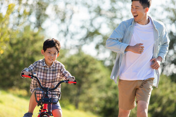 Father teaching son to ride bike