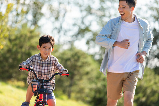 Father teaching son to ride bike