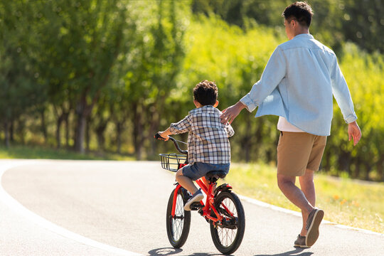 Father teaching son to ride bike