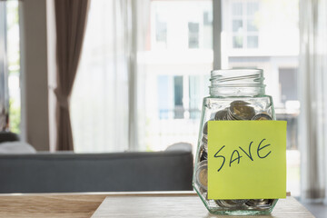 Saving money concept,coin money in glass bottle on work table,selective focus.