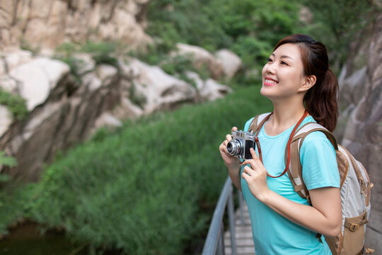 Happy young woman taking photos outdoors
