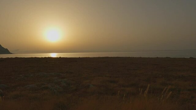 Breathtaking sunset at Baia Santa Margherita at Monte Cofano Sicilian natural reserve as seen from moving car, Italy. Slow-motion