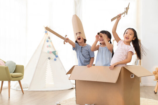 Cute Chinese children playing warriors in living room