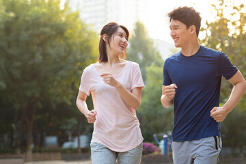 Happy young couple jogging in park