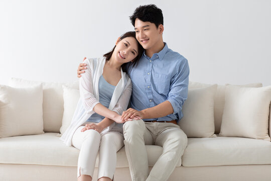 Cheerful young couple sitting on sofa