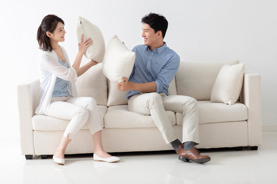 Cheerful young couple sitting on sofa