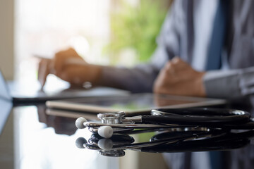 Male doctor work on laptop computer at office desk.