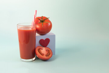 The concept of a positive attitude to tomato juice. Tomato juice, podium with a heart and half a tomato on a light background