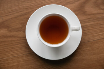 Top view of a cup of tea isolated on a wooden  background.