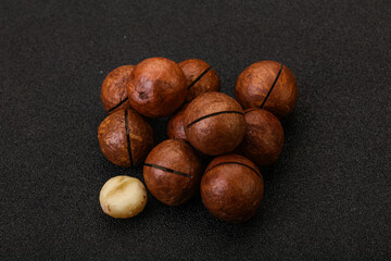 Brown macadamia nut heap over background