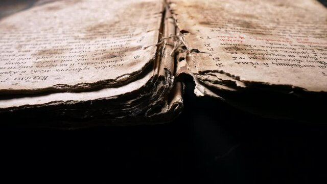 Background of book with ancient writings, mystical secrets of past, mysteries of history. Slider shot macro view of religious literature, archival manuscripts
