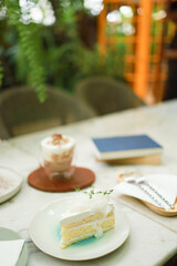 Coconut Cake and Coffee in a cafe on the blur background. traditional dessert Sliced of delicious coconut layer cake
