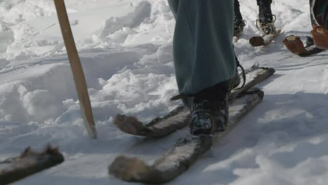 Three ancient fur skiers dressed in traditional Mongolian clothing deel walking in snow. Hemu Village, Xinjiang, China. Slow motion close up
