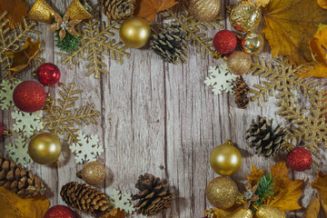 Red and gold Christmas ornament corner border banner. Above view on a rustic wood background.