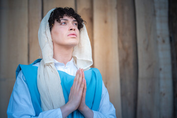 Portrait of an androgynous virgin mary praying while looking up