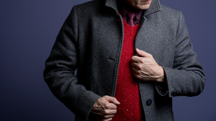 Knitted red waistcoat, gray coat and tie. Close up.