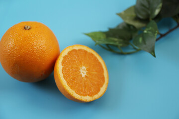 水色の背景に置かれた半分にカットされたオレンジ