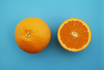 水色の背景に置かれた半分にカットされたオレンジ