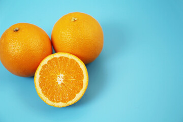 水色の背景に置かれた半分にカットされたオレンジ