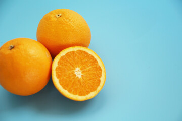 水色の背景に置かれた半分にカットされたオレンジ