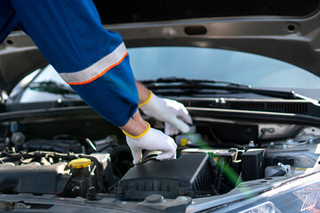 professional mechanic working in the auto service fixing car problems, work under the hood