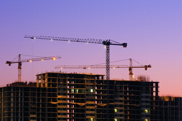 construction site at dusk after sunset. Construction of a multi-storey building. Silhouettes of...