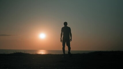 sport young man walking towards sea shore warm up and making exercise checking time on smart watch result during training outdoors