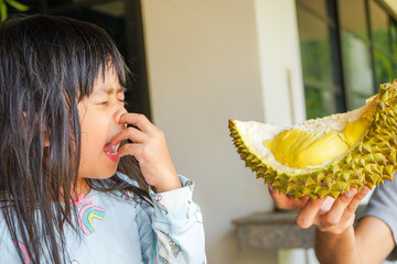 Asian little cute girl dislikes eating durian. Durian fruit is so smelly and pungent, good taste...