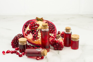 pomegranate oil in bottles on the background of the fruit of pomegranate for skin care. universal cosmetic, antioxidant.