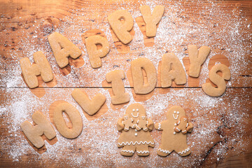 Background With Happy Holidays Written With Cookie Dough Letters and Powdered Sugar