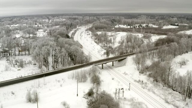 Winter flight. Train approaching bridge. Overacts days. Neutral Color. Frozen trees.