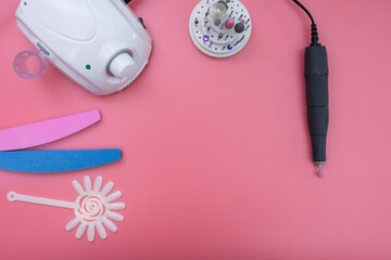 Set of cosmetic tools for manicure and pedicure on a pink background. Gel polishes, nail files, nail scissors, nippers on top. copy space
