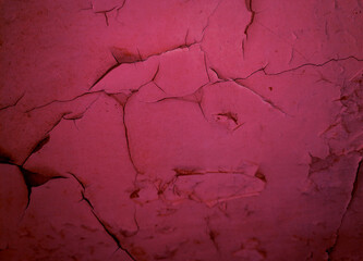 A close-up of the cracks on a pink wall as a background.
