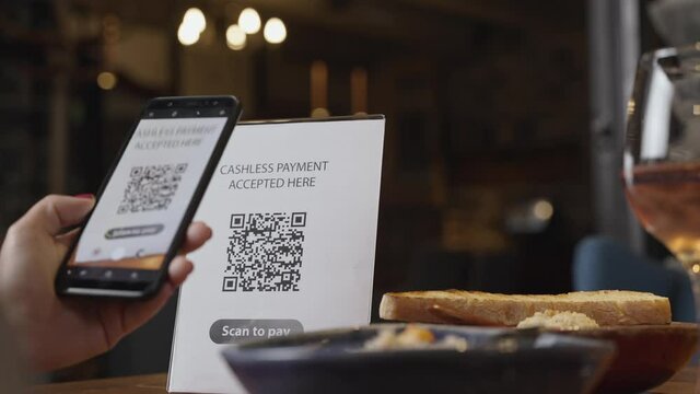 Hand scanning QR code. Contactless payment by smartphone via QR code, use cashless, nfc, scan app, sale in, take out, food drink order in restaurant. Concept of shopping