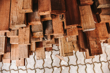A huge pile of planks stacked in a sawmill. Top view of shot of wood planks at a construction site.