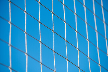 Football or soccer net background, back view of goal net with blurred stadium and field field field.